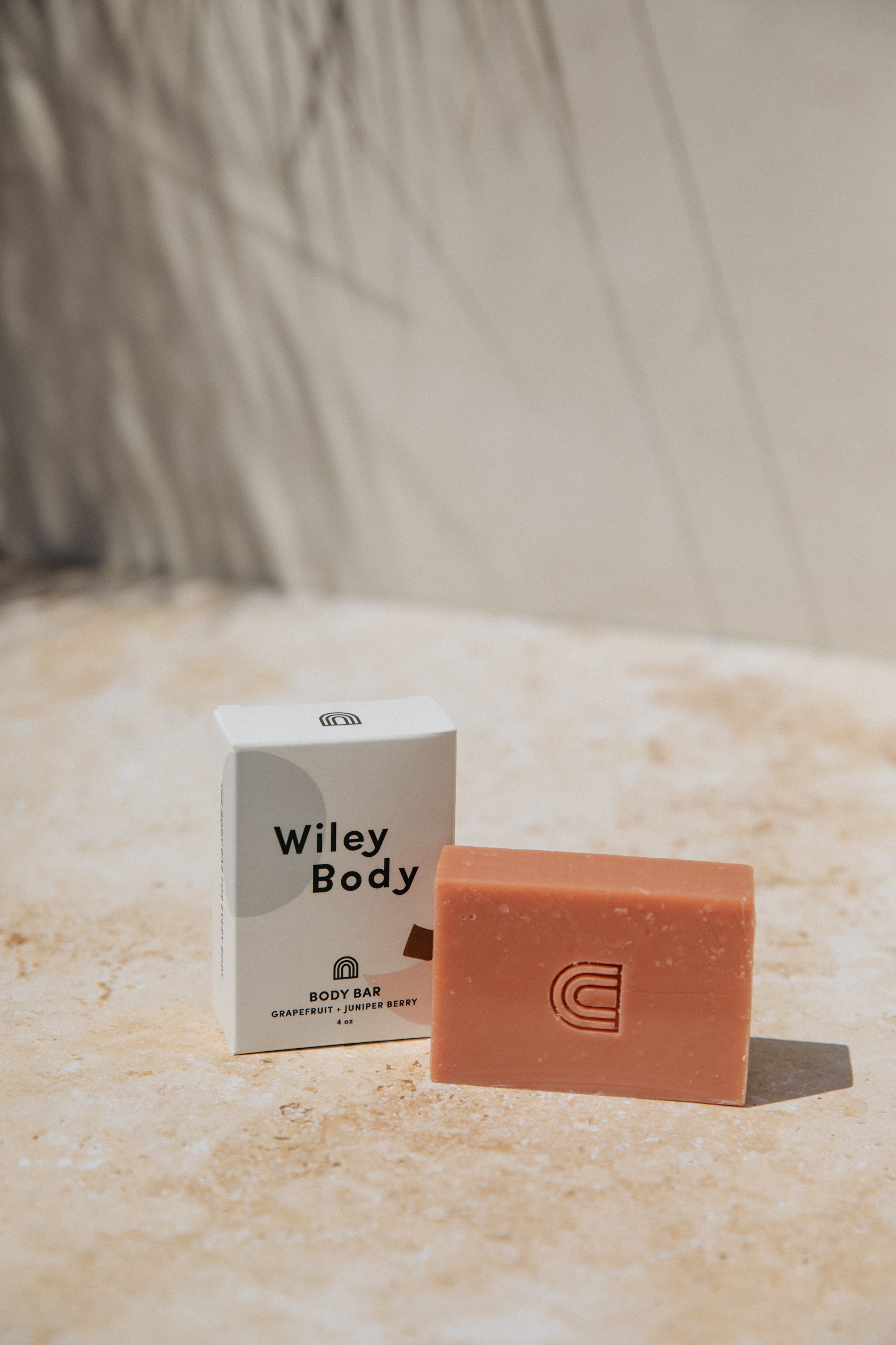 A small soap box that reads "Body Bar" next to a soap bar on it's side